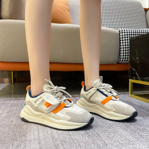 Women's leather colorblock running sneakers in black, orange, and khaki with lace-up closure